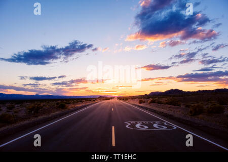 Sonnenuntergang im Hintergrund der Route 66, während auf einem Roadtrip durch die Mojave Wüste im südlichen Kalifornien Stockfoto