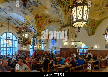 Die Menschen trinken und essen im Hofbräuhaus in München, Deutschland Stockfoto