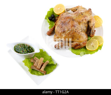Ganzen gebratene Hähnchen mit Gemüse auf Teller, isoliert auf weißem Stockfoto