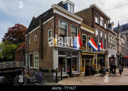 Holland, Niederlande, 23. April 2019. Gouda Altstadt, der berühmten alten Bauern cheese shop auf einer Straße der Fassaden der Häuser im holländischen Stil. Stockfoto