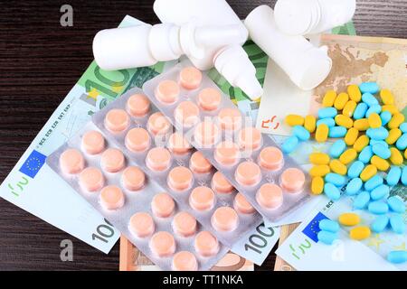 Verschreibungspflichtige Medikamente auf Geld Hintergrund die steigende Kosten der Gesundheitsversorgung. Auf hölzernen Hintergrund Stockfoto