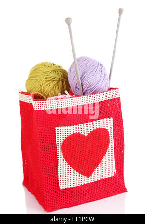 Kammgarn Kugeln von Garn und Stricknadeln aus Holz im rustikalen craft Tasche, auf weissem isoliert Stockfoto