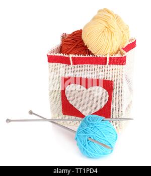 Kammgarn Kugeln von Garn und Stricknadeln aus Holz im rustikalen craft Tasche, auf weissem isoliert Stockfoto