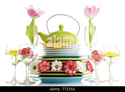 Stapel bunter Keramik Geschirr und Blumen, isoliert auf weißem Stockfoto