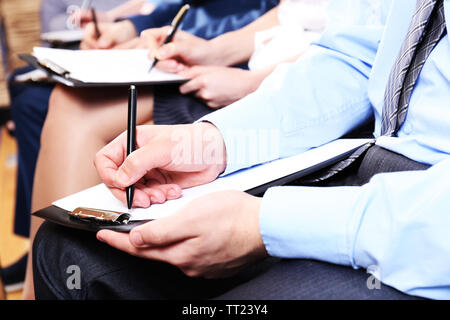 Hände halten Stifte und Notizen zu machen bei der Konferenz Stockfoto