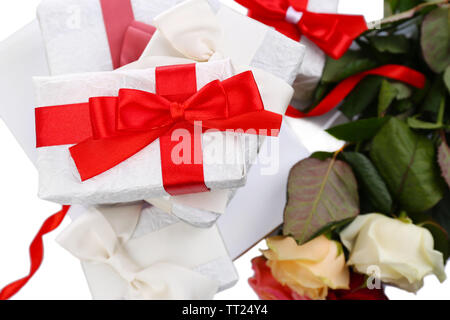 Schöne Geschenke mit roten Bändern und Blumen, in der Nähe Stockfoto