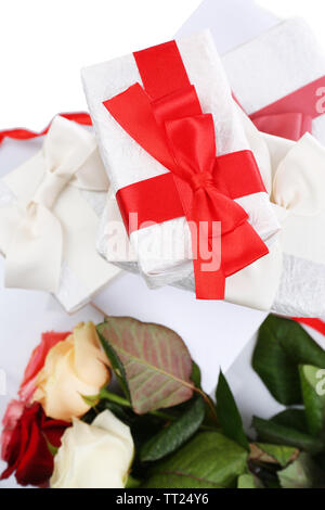 Schöne Geschenke mit roten Bändern und Blumen, in der Nähe Stockfoto