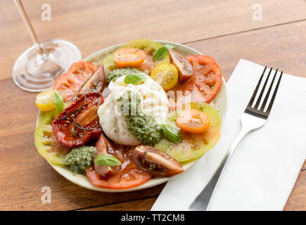 Frische mehrere farbige Tomatensalat mit Büffelmozzarella und grüne Basilikum Pesto Stockfoto