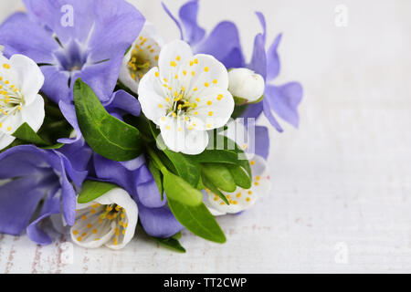 Schönen Blumenstrauß mit Immergrün Blüten auf hölzernen Tisch Stockfoto