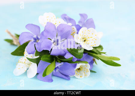 Schönen Blumenstrauß mit periwinkle Blumen auf blau Tabelle Stockfoto