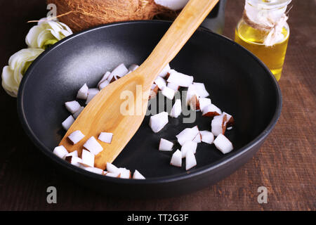 Kokosnüsse auf Pan und Kokosnussöl auf hölzernen Tisch Stockfoto
