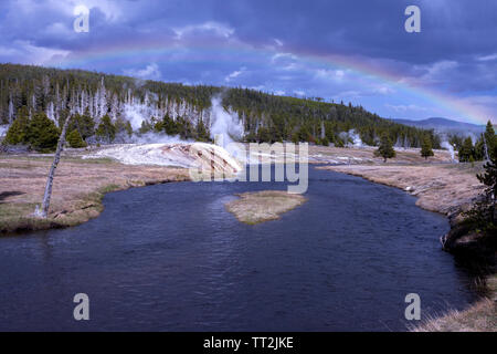 Ein Regenbogen Bögen über die Upper Geyser Basin und Firehole River in der Nähe von treuen alten Dorf im Yellowstone National Park. Stockfoto