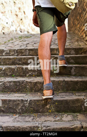 Wandern im Obergeschoss: Detailansicht der Beine des Menschen braun Leder Schuhe gehen im Obergeschoss. Sommer im alten italienischen Stadt reisen. Stockfoto