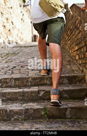 Wandern im Obergeschoss: Detailansicht der Beine des Menschen braun Leder Schuhe gehen im Obergeschoss. Sommer im alten italienischen Stadt reisen. Stockfoto