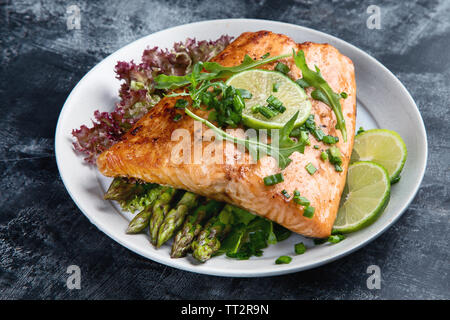 Gegrillter Lachs mit Gemüse auf schwarzem Hintergrund Stockfoto