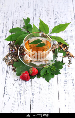 Komposition mit trockene Blumen frische Blätter und Früchte Zutaten für Kaffee und Glas Schale, auf Farbe Holz- Hintergrund Stockfoto
