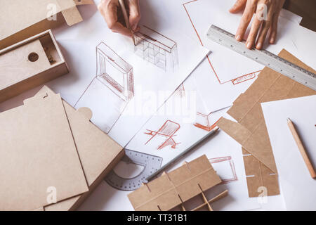 Designer zeichnet ein Mockup für Handwerk Karton. Entwicklung des Verpackungsdesigns Skizze. Stockfoto