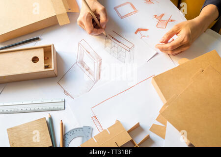 Designer zeichnet ein Mockup für Handwerk Karton. Entwicklung des Verpackungsdesigns Skizze. Stockfoto