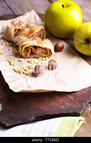 Leckere hausgemachte Apfelstrudel auf einer Papierserviette, auf hölzernen Hintergrund Stockfoto