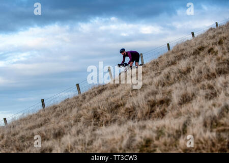 Ein Mann reitet ein touring Bike off road in Northumberland National Park. Stockfoto