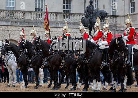 Mitglieder des Queen's Life Guard (roten) und den Blues und Royals (blau Tuniken) ändern Sie die Sicherung während der täglichen zeremonielle in Horse Guards Parade, am 11. Juni 2019 in London, England. Rettungsschwimmer haben Wache an Horse Guards, der offizielle Eingang zum St. James und der Buckingham Palast stand, seit der Wiederherstellung der König Charles II. im Jahre 1660. Stockfoto