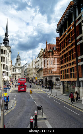 London Red Bus in Bewegung ist durch eine Straße mit gotischen Gebäuden auf der beiden Seiten. Stockfoto