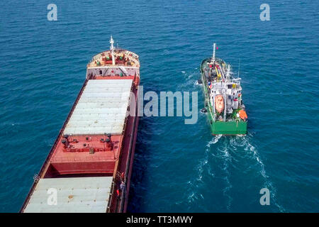 Tanken auf See - Kleine Öl Produkte Betankung einen großen Bulk Carrier, Luftbild. Stockfoto