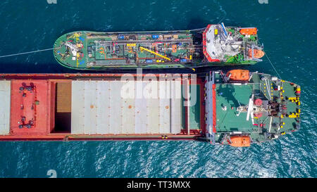 Tanken auf See - Kleine Öl Produkte Betankung einen großen Bulk Carrier, Luftbild. Stockfoto