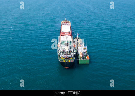 Tanken auf See - Kleine Öl Produkte Betankung einen großen Bulk Carrier, Luftbild. Stockfoto