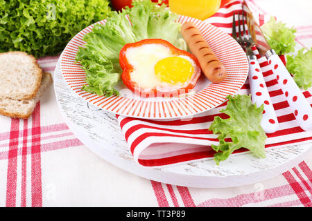 Rührei mit Würstchen und Gemüse auf dem Teller serviert auf Stoff Hintergrund Stockfoto