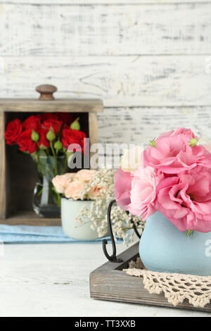 Schönen Blumen in Vasen auf Holz- Hintergrund Stockfoto