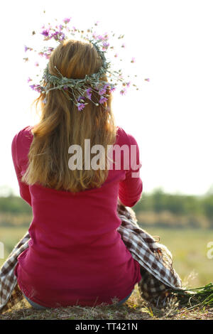 Schöne Mädchen sitzen auf haystack im Feld Stockfoto