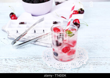 Kalten Cocktail mit Waldbeeren, in Eiswürfel auf hölzernen Tisch Hintergrund eingefroren Stockfoto