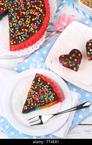 Lecker Regenbogen Kuchen auf Platte, am Tisch, auf einem hellen Hintergrund Stockfoto