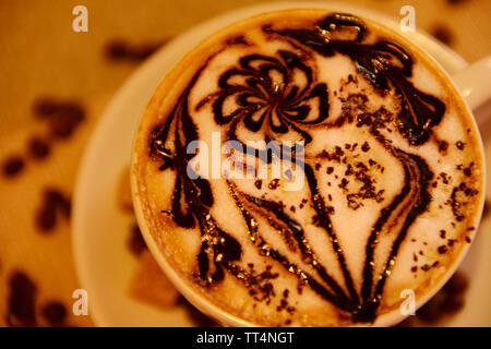Tasse Kaffee mit niedlichen Zeichnung auf dem Tisch, in der Nähe Stockfoto