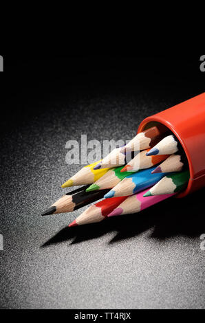 Buntstifte auf einem schwarzen genarbte Oberfläche der Tabelle Stockfoto