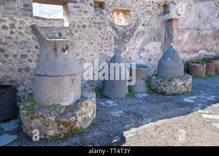 Mühlsteine in einer Bäckerei Pistrinium in der archäologischen Ausgrabungen der Antike römische Stadt Pompeji. Stockfoto