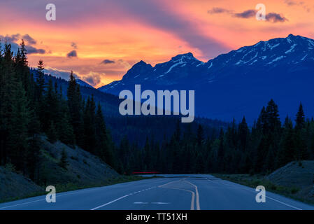 Schönen Sonnenuntergang über einem Berg Straße, die durch die Kanadischen Rocky Mountains in der Icefields Parkway in der Nähe von Jasper, Jasper National Park, Alberta führt, können Stockfoto