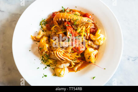 Spaghetti mit Meeresfrüchten, Speck und frischen Tomaten Stockfoto
