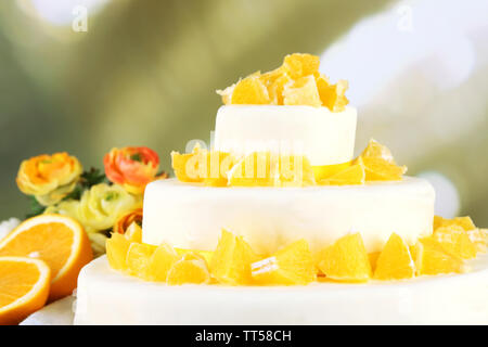 Wunderschöne Hochzeitstorte mit Orangen auf hellen Hintergrund Stockfoto