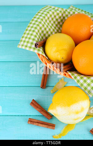 Zitronen und Orangen auf Serviette in Korb und Schälmesser auf Blau Holz- Hintergrund Stockfoto