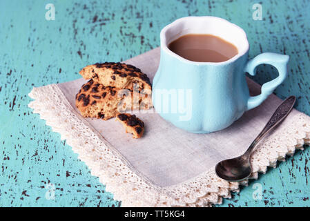 Tasse Kaffee mit Plätzchen und Serviette auf hölzernen Tisch Stockfoto