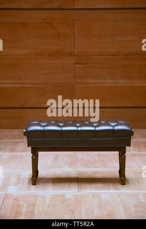 Braun Holz- Klavier Hocker auf dem hölzernen Bühne in Concert Hall Stockfoto