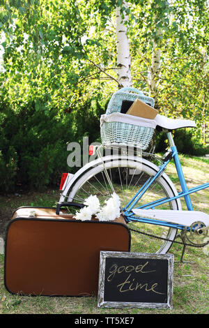 Fahrrad- und braunen Koffer mit Picknick im Schatten in Park Stockfoto