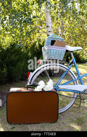 Fahrrad- und braunen Koffer mit Picknick im Schatten in Park Stockfoto