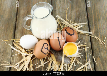 Eier und frische Milch in Glas Krug, auf Holz- Hintergrund. Organische Produkte Konzept Stockfoto