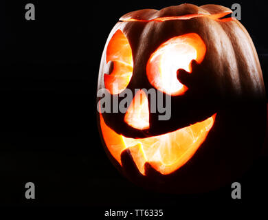 Halloween Kürbis auf dem Tisch auf schwarzem Hintergrund Stockfoto