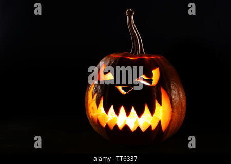 Halloween Kürbis auf dem Tisch auf schwarzem Hintergrund Stockfoto