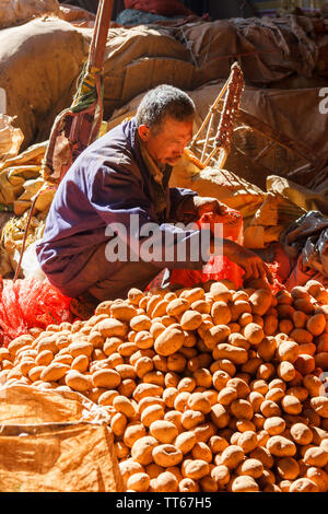 01 Feb 2017 - Dali, China Mann Kartoffeln zum Verkauf vorbereitet Stockfoto