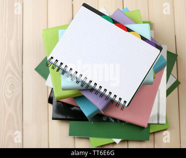 Notebook auf Stapel Bücher und Zeitschriften auf hölzernen Hintergrund Stockfoto